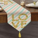 - UcgenRunner-8219-Gorsel1 - Realhomes Realhomes Beyaz Zemin Üzerinde Gold Detaylı Love Yazılı Dijital Baskılı Özel Tasarım Püsküllü Şönil Üçgen Runner Realhomes